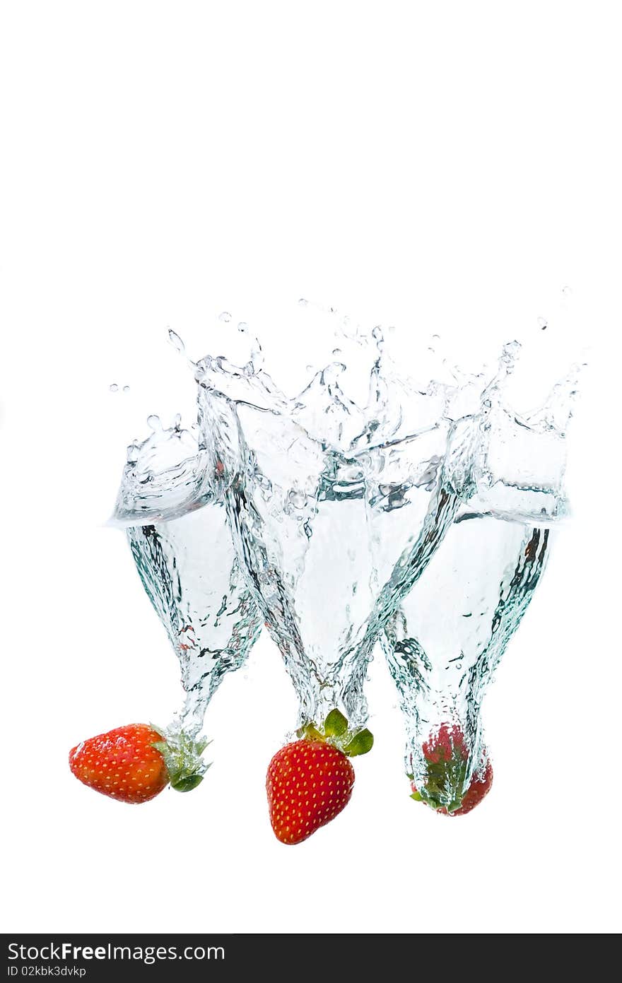 Three fresh strawberries splashing into water. Three fresh strawberries splashing into water