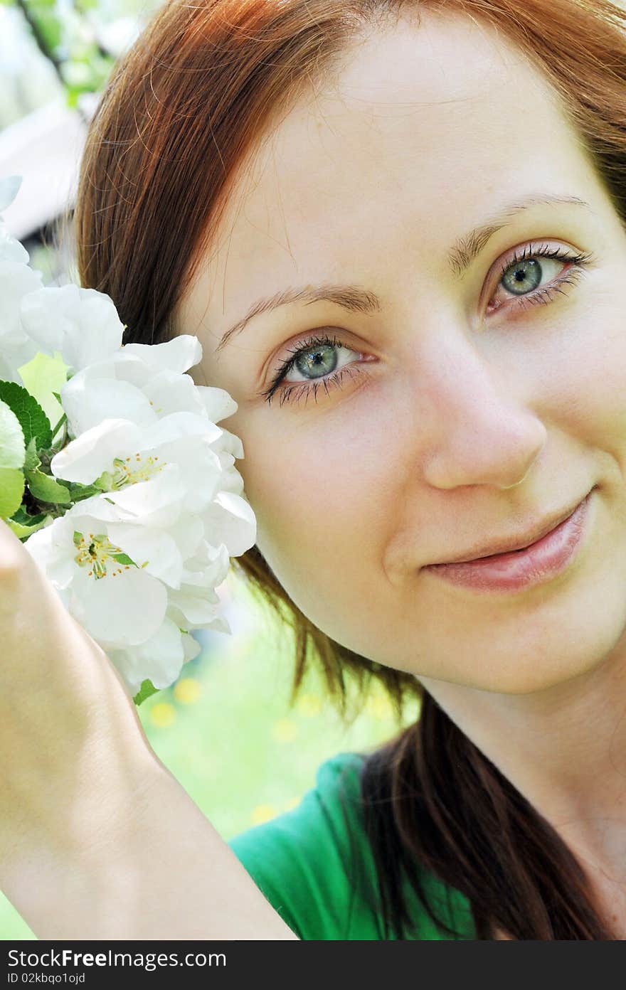 Young  woman standing at apple tree in white blossom. Young  woman standing at apple tree in white blossom