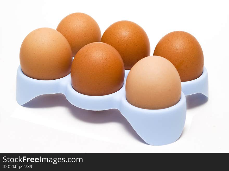 Eggs in tray, white background, close up.