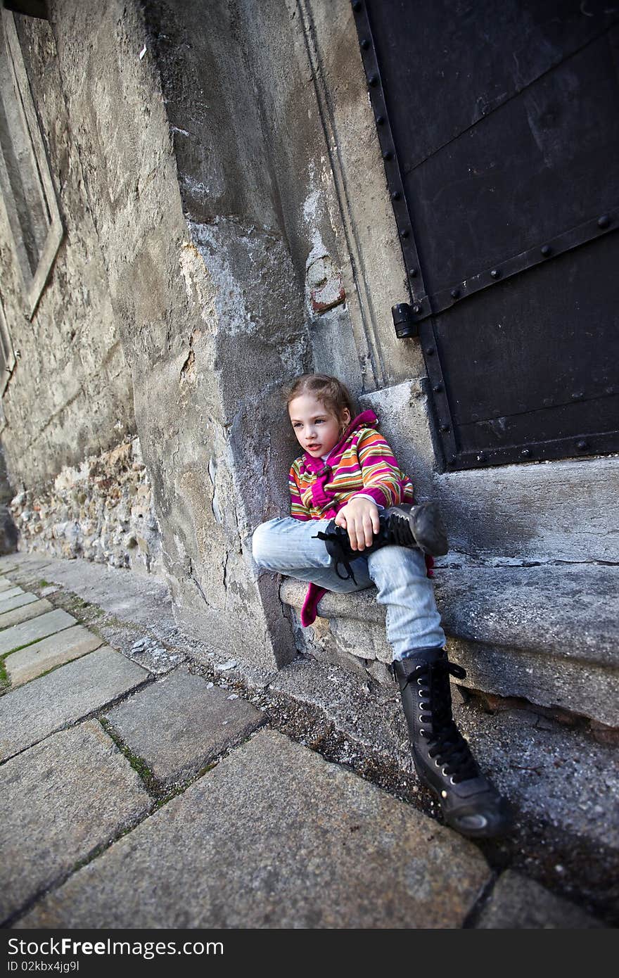 Girl sitting on steps on old wall background