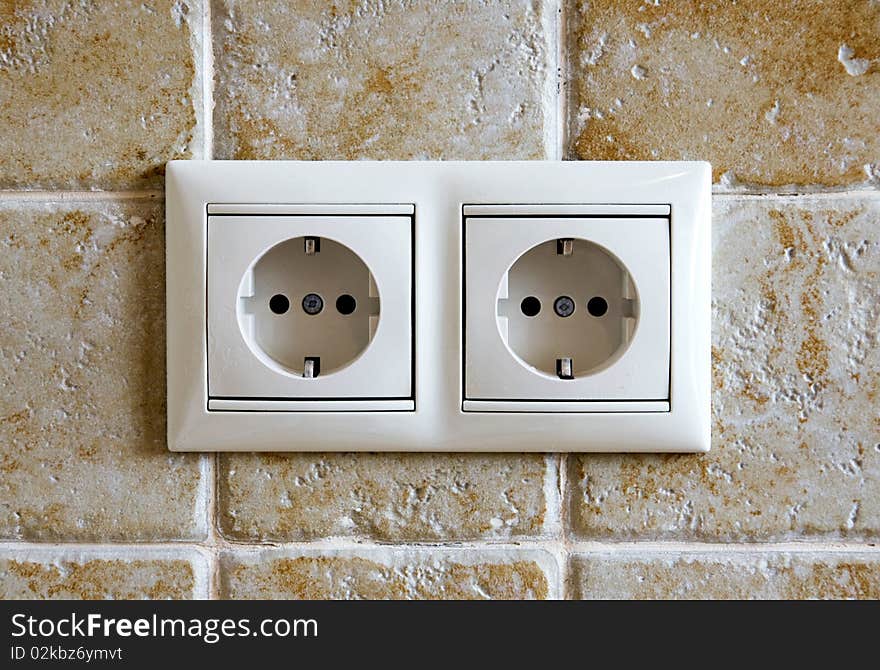 Two sockets against a tile