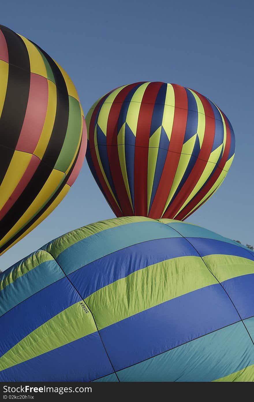 Partially inflated hot air balloons on the ground at the Blossom Time Festival in Chagrin Falls, Ohio. Vertical shot.