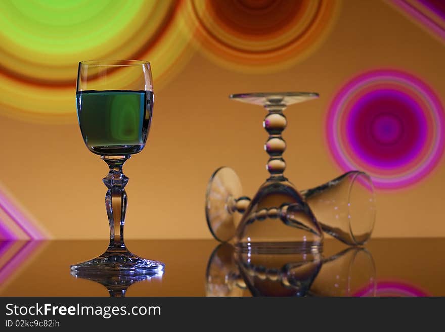 Green liqueur in wine glass on colorful abstract background. Green liqueur in wine glass on colorful abstract background