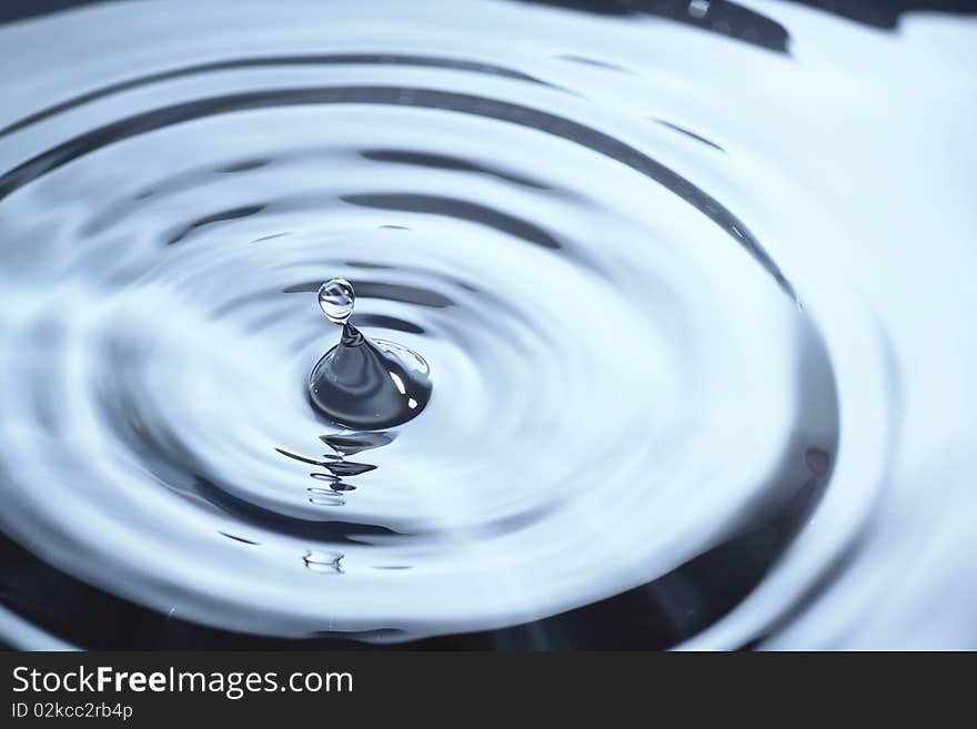 The round transparent drop of water, falls downwards