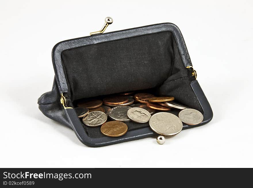 Open navy blue coin purse with lots of US coins on isolated white background. Open navy blue coin purse with lots of US coins on isolated white background