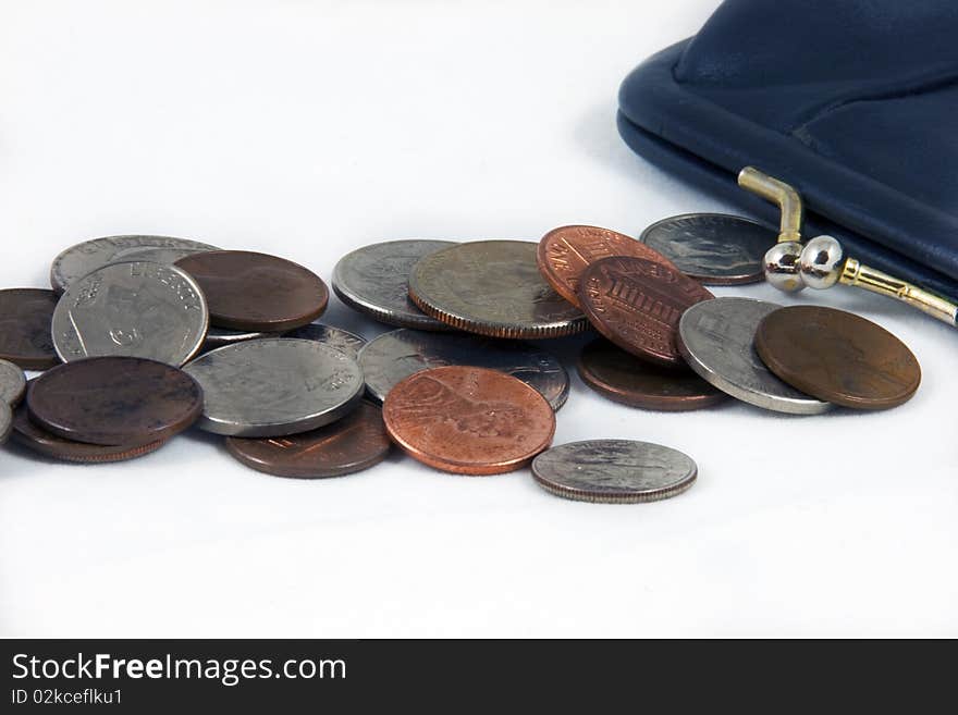 US coins and a navy blue closed money purse on an isolated white background. US coins and a navy blue closed money purse on an isolated white background