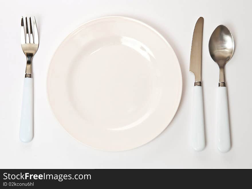 Set of kitchen object. The spoon, fork and knife with plate on a grey background. Set of kitchen object. The spoon, fork and knife with plate on a grey background.