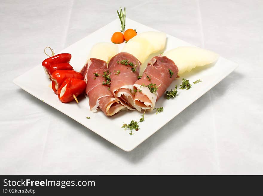 Melon pieces with bacon and filled red paprikas. Melon pieces with bacon and filled red paprikas