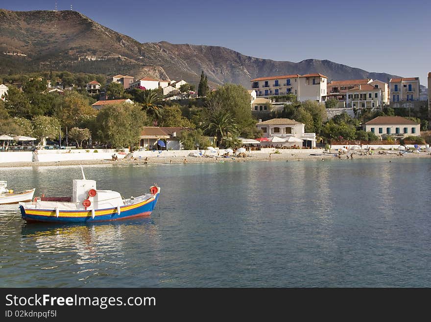 View across Assos bay to colorful villas, with colorful fishing boat in foreground. View across Assos bay to colorful villas, with colorful fishing boat in foreground.