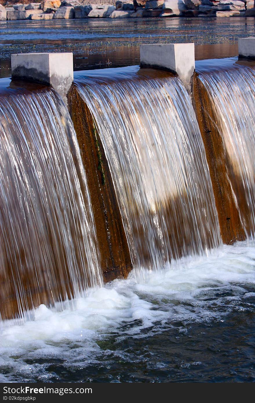 The curtain of water falling over a dam.