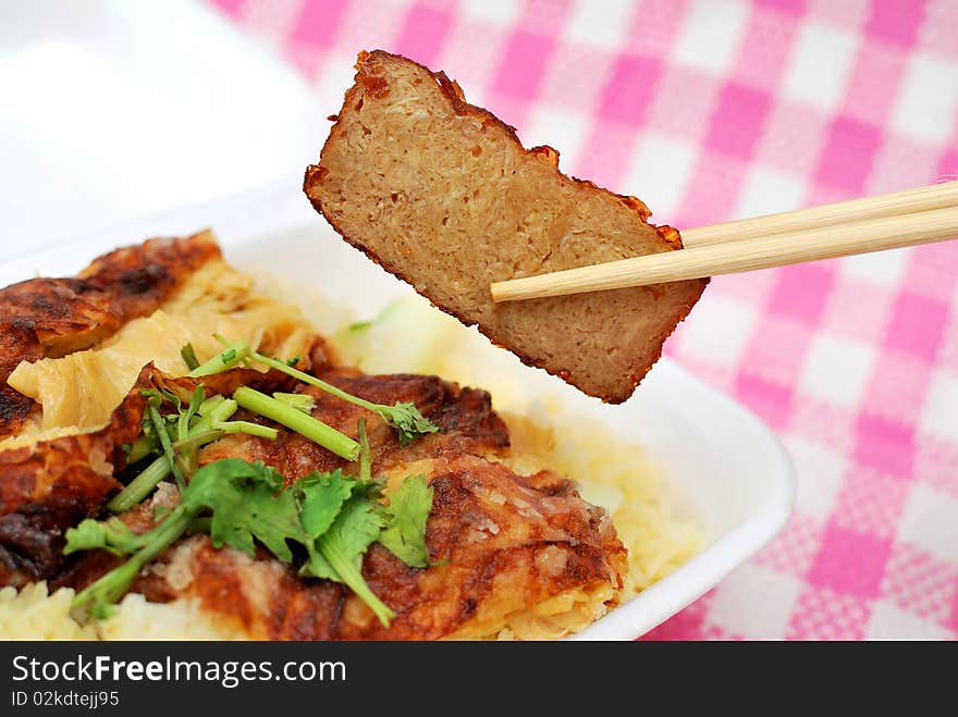 Chopsticks picking up roasted pork slice