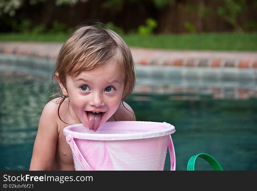 Little Girl Playing with Bucket by Pool. Little Girl Playing with Bucket by Pool