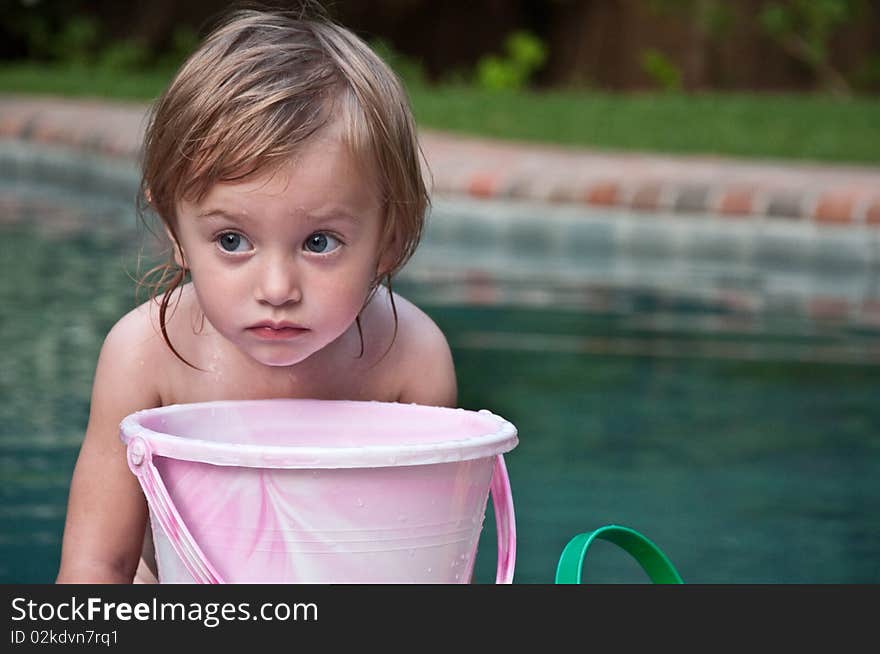 Little Girl Pondering with Bucket by Pool. Little Girl Pondering with Bucket by Pool