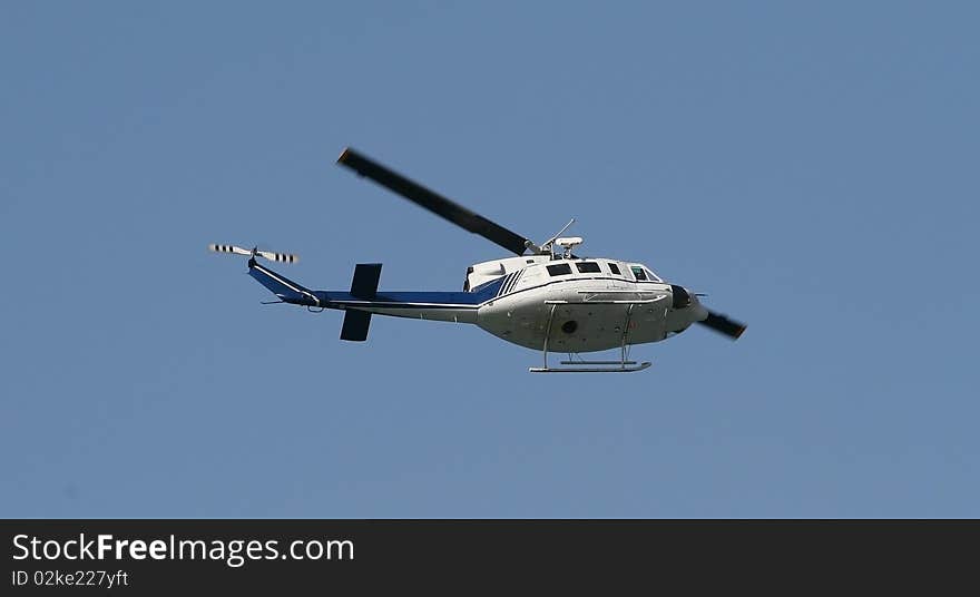 The helicopter flying on the dark blue sky