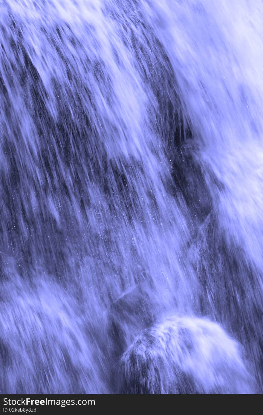 Waterfall into river with fall trees in background