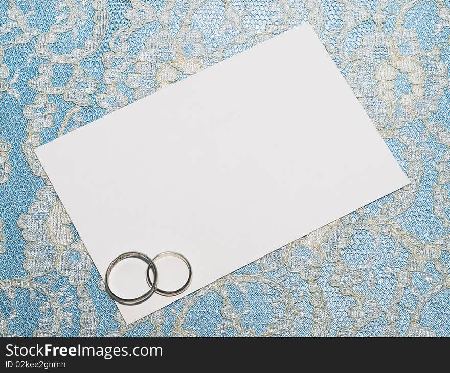 White card for congratulation on a background from blue  silk and white lace