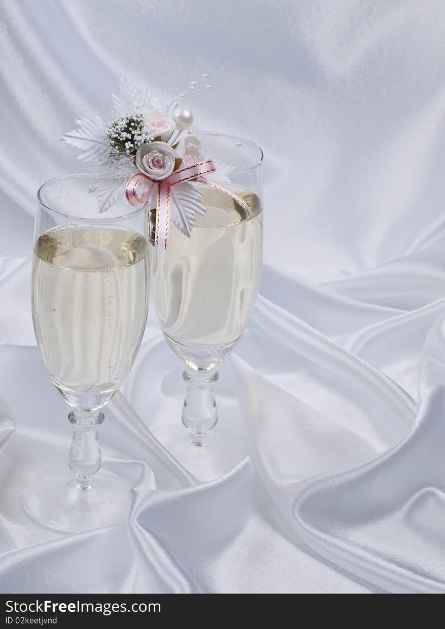 Glasses with champagne and weddings buttonholes on a dark background