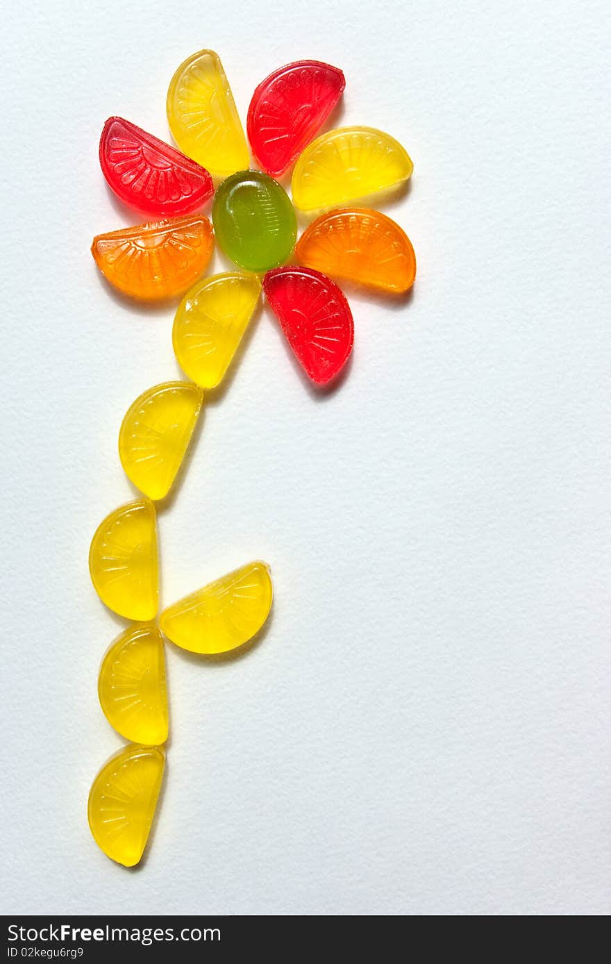 Funny flower combined from sugar candies on a white paper. Funny flower combined from sugar candies on a white paper