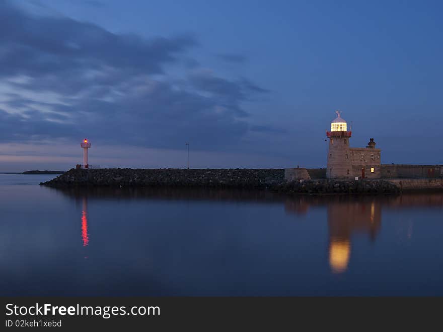 Lighthouse at night with reflections in water