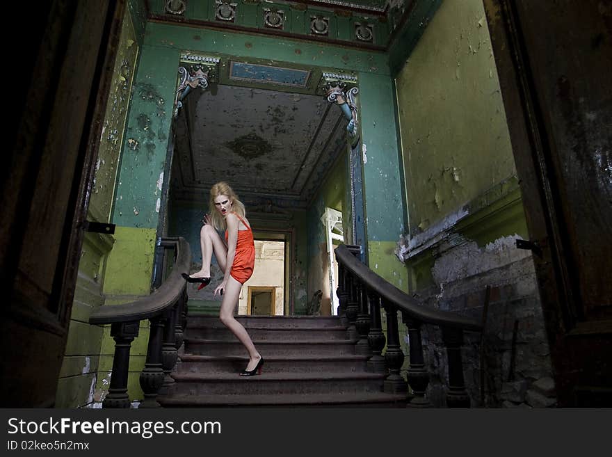 Fashion model posing on the staircase in the abandoned house