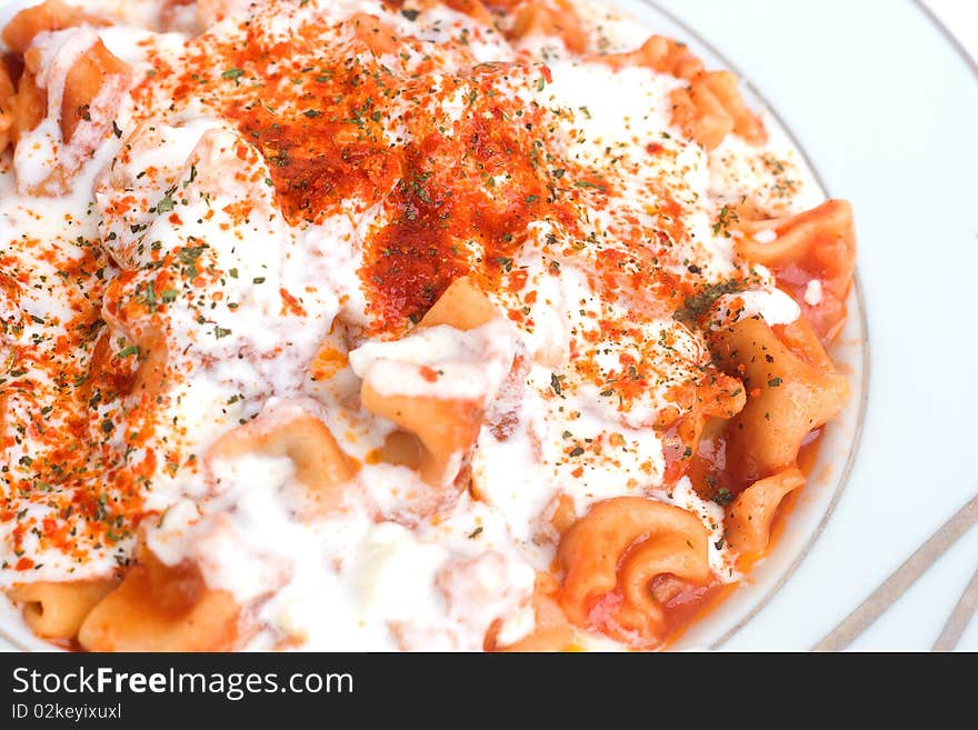 Turkish ravioli with spices and yogurt background