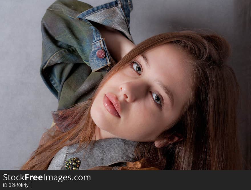 A portrait of a teenage model's face as she poses in a jean jacket. A portrait of a teenage model's face as she poses in a jean jacket