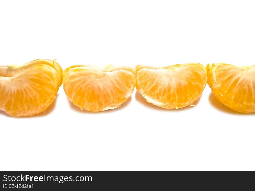 Row of mandarin segmants. Focus in the center. Isolated over white background. Row of mandarin segmants. Focus in the center. Isolated over white background