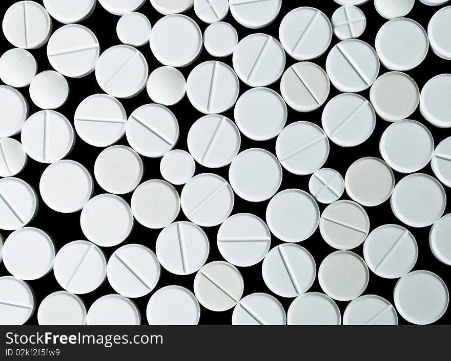 White tablets on the black background. Top view. White tablets on the black background. Top view