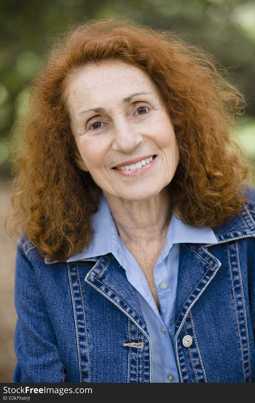 Portrait of an Attractive Redhead Senior Woman in a Denim Jacket. Portrait of an Attractive Redhead Senior Woman in a Denim Jacket