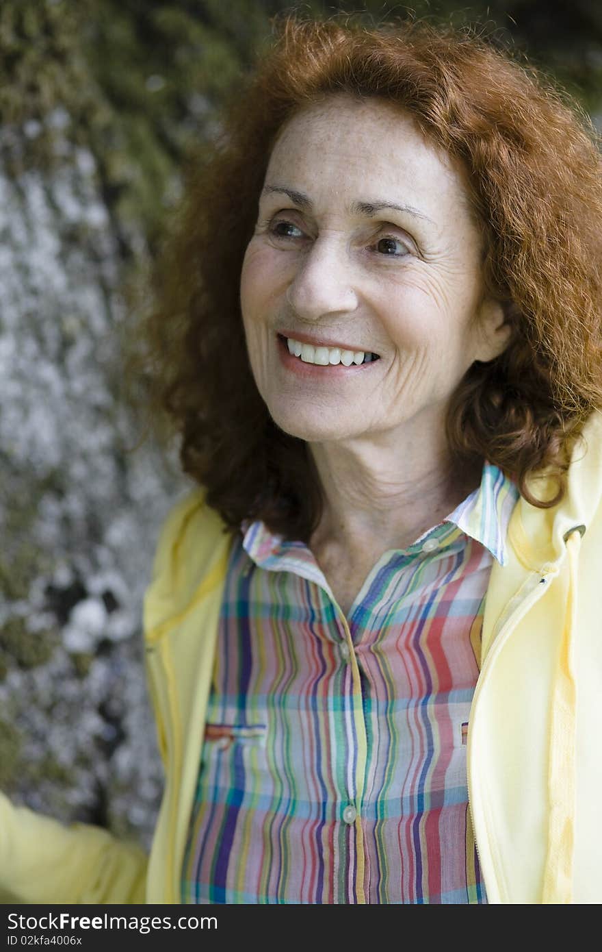 Profile of an Attractive Redhead Senior Woman Outdoors by a Treetrunk. Profile of an Attractive Redhead Senior Woman Outdoors by a Treetrunk