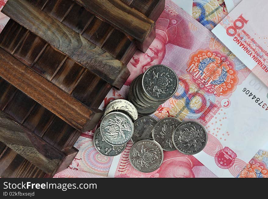 Aged wooden box and coins on money notes