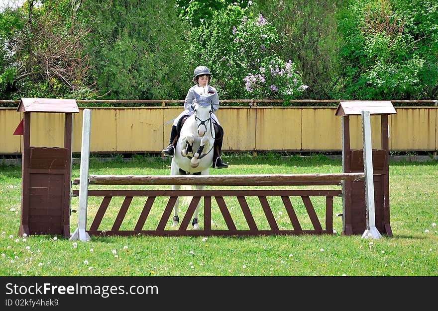 Young boy riding white horse