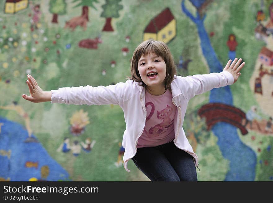 Happy young girl posing and jumping with abstract urban style painting bacground begind. Happy young girl posing and jumping with abstract urban style painting bacground begind