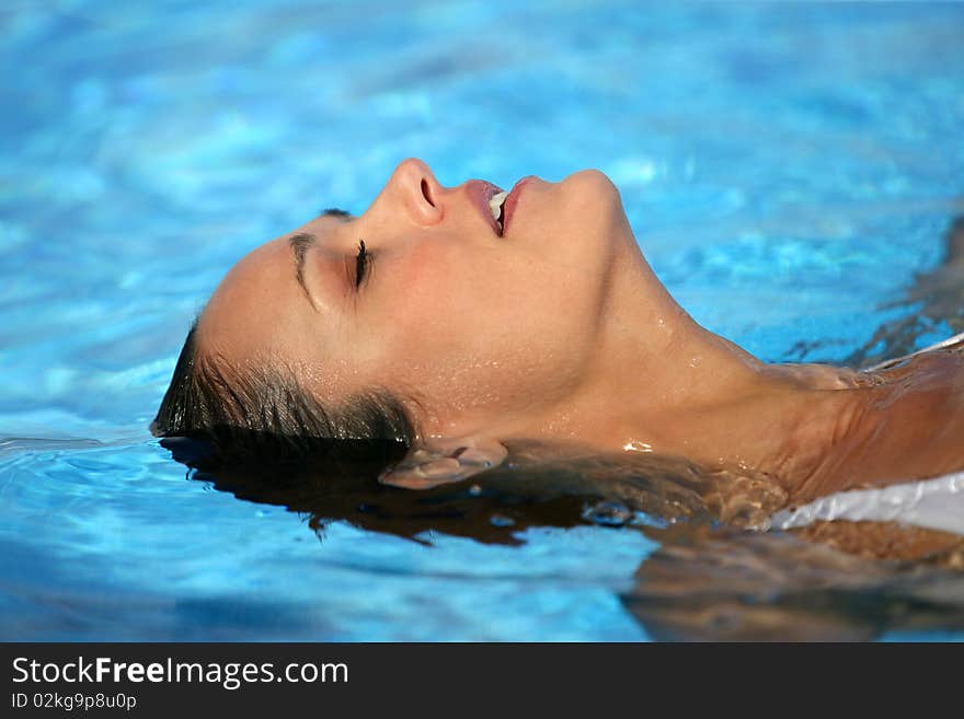 Closeup of young woman with eyes shut in a pool. Closeup of young woman with eyes shut in a pool