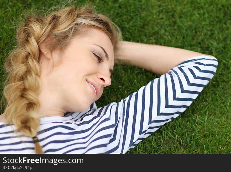 Portrait of the blond girl on the grass background. Portrait of the blond girl on the grass background