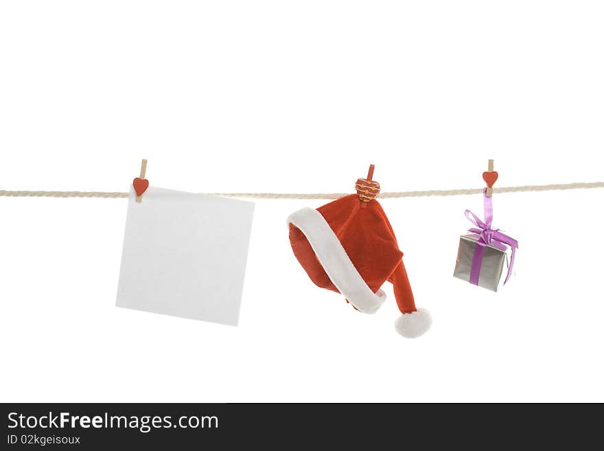 White blank, gift box and a red Santa's hat hanging on a rope. Isolated on white background. White blank, gift box and a red Santa's hat hanging on a rope. Isolated on white background