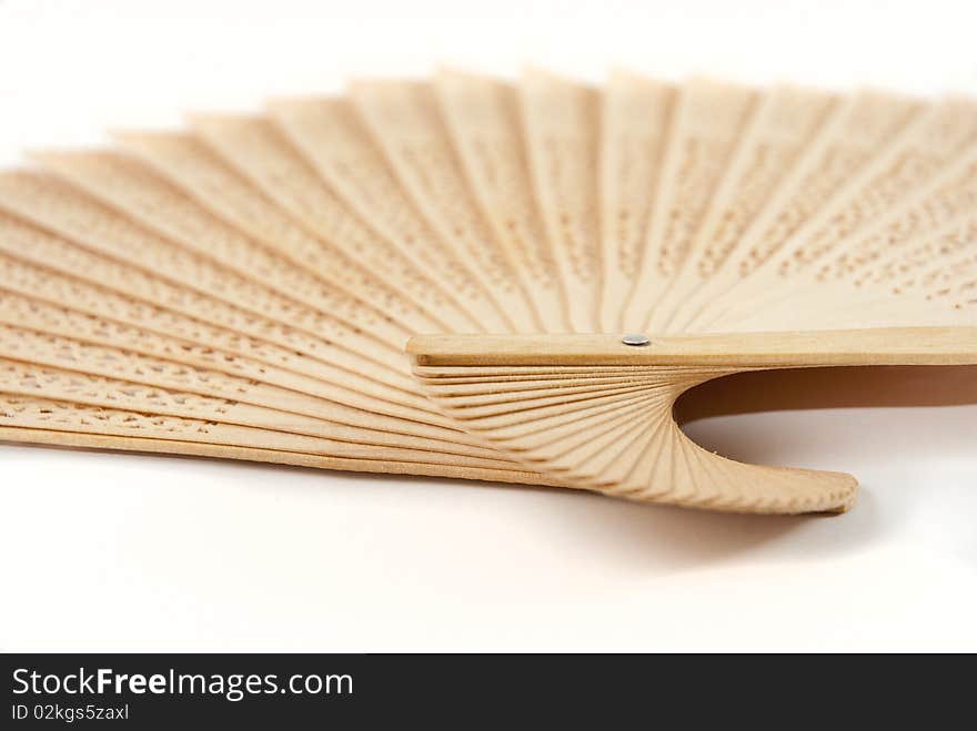 Light brown wooden Chinese fan, fanned out, on a white background