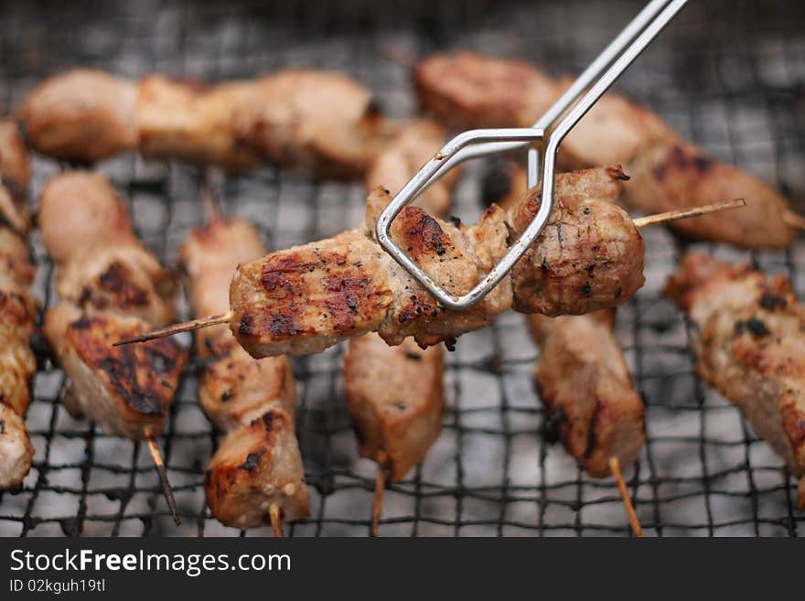 Roasted meat on wood sticks prepared for eating. Barbecue. Shallow depth of field. Roasted meat on wood sticks prepared for eating. Barbecue. Shallow depth of field.