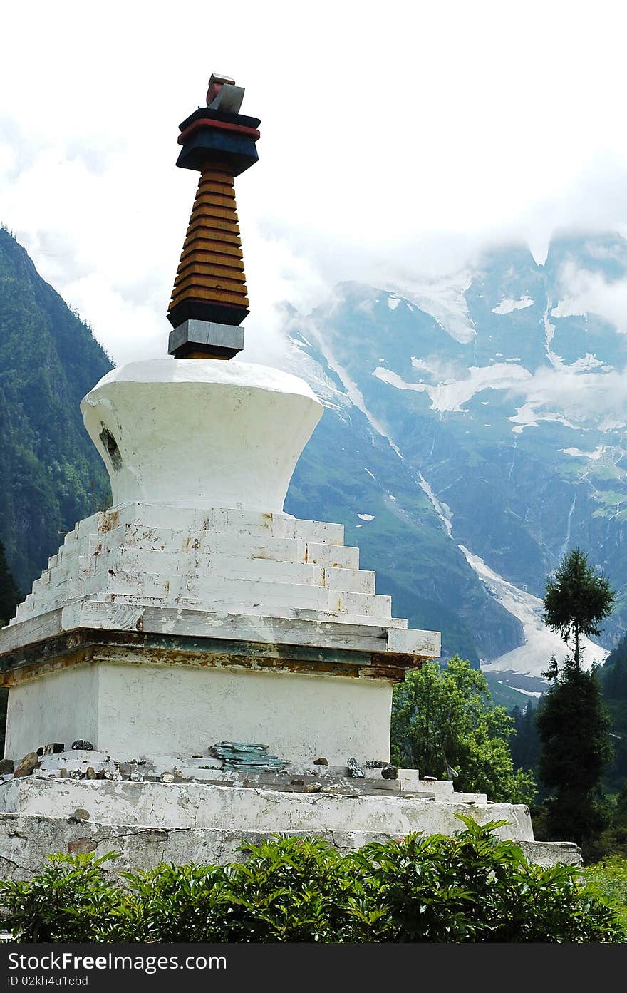 Scenery of white stupa with snow mountains as background in a village named Yubeng in Shangrila,Yunnan,China