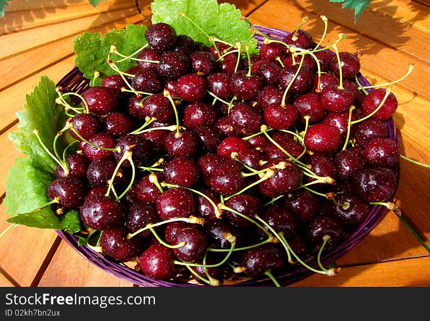 Basket of fresh red cherries with green leaves. Basket of fresh red cherries with green leaves