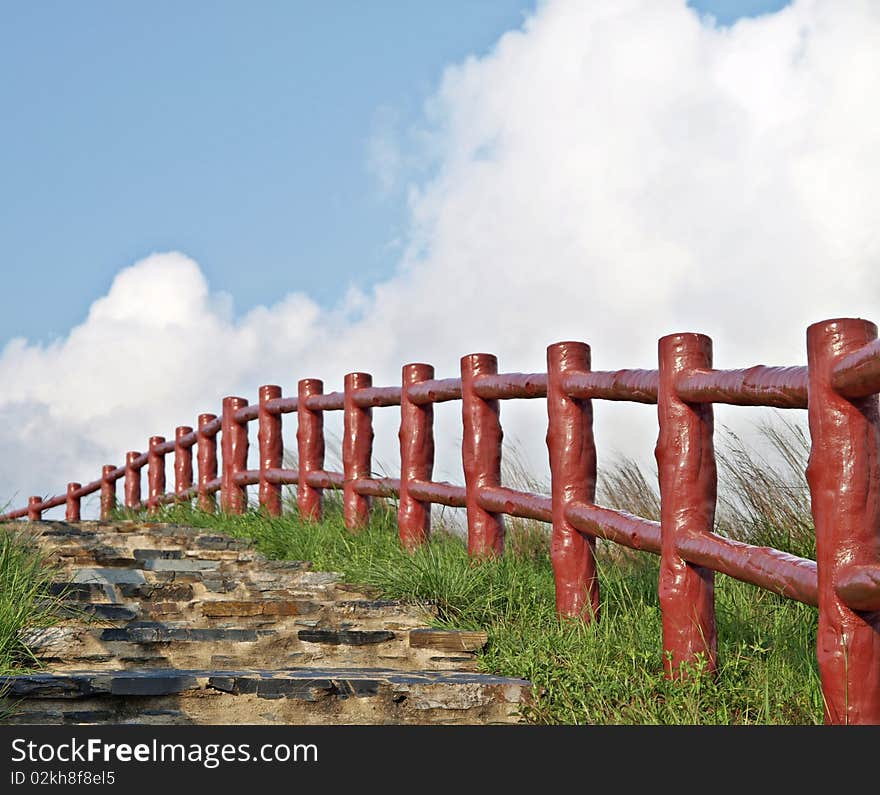 Red fences leading the path under beautiful blue s