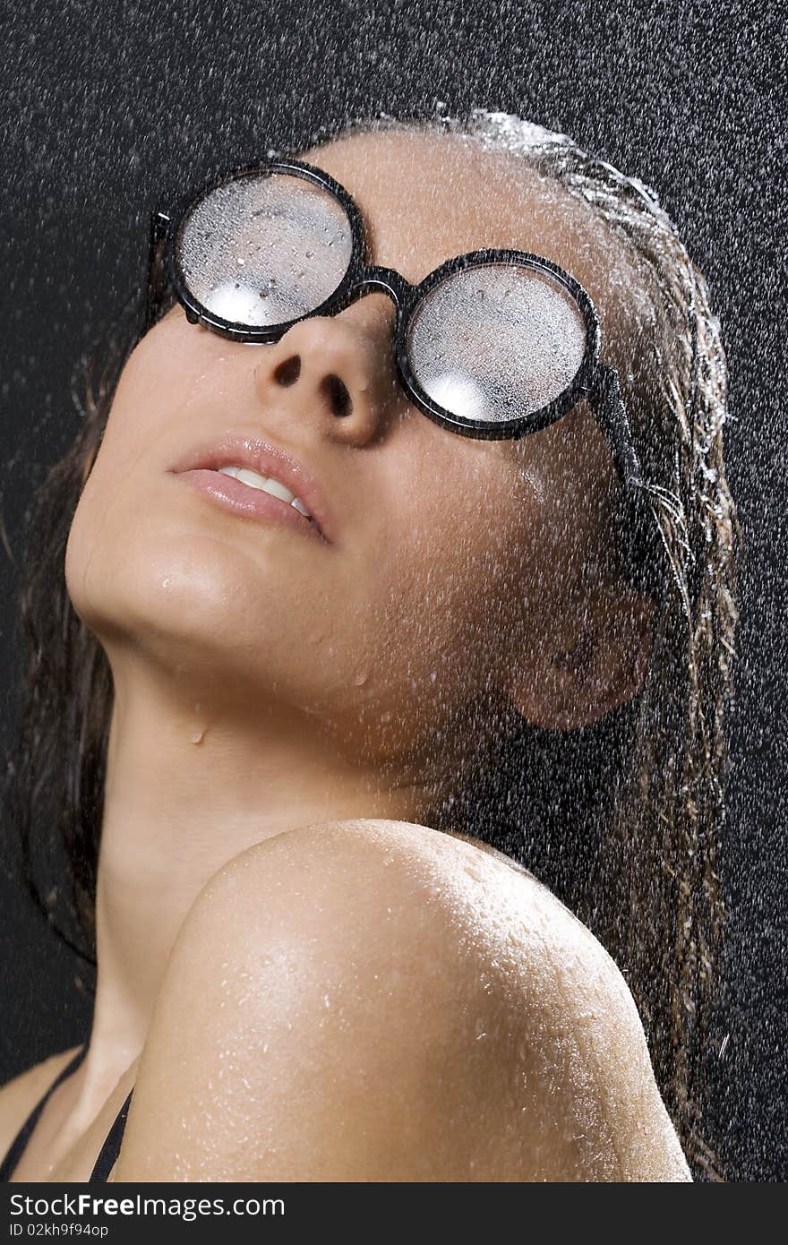 Portrait of the smiling brunette in drop of water on black background. Portrait of the smiling brunette in drop of water on black background