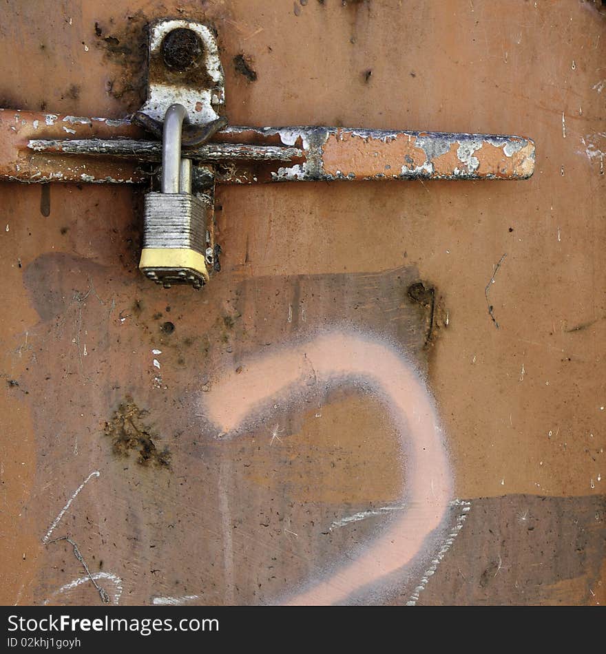 Old wooden door with paint marks and rusty padlock on lock. Old wooden door with paint marks and rusty padlock on lock.