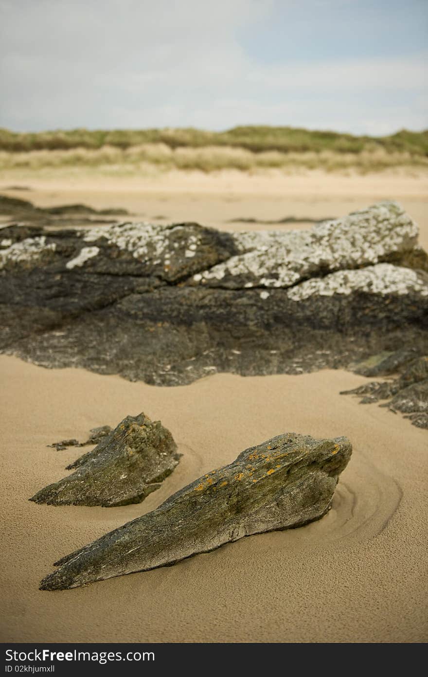 Rock formation in the sand on sea shore with copy space.