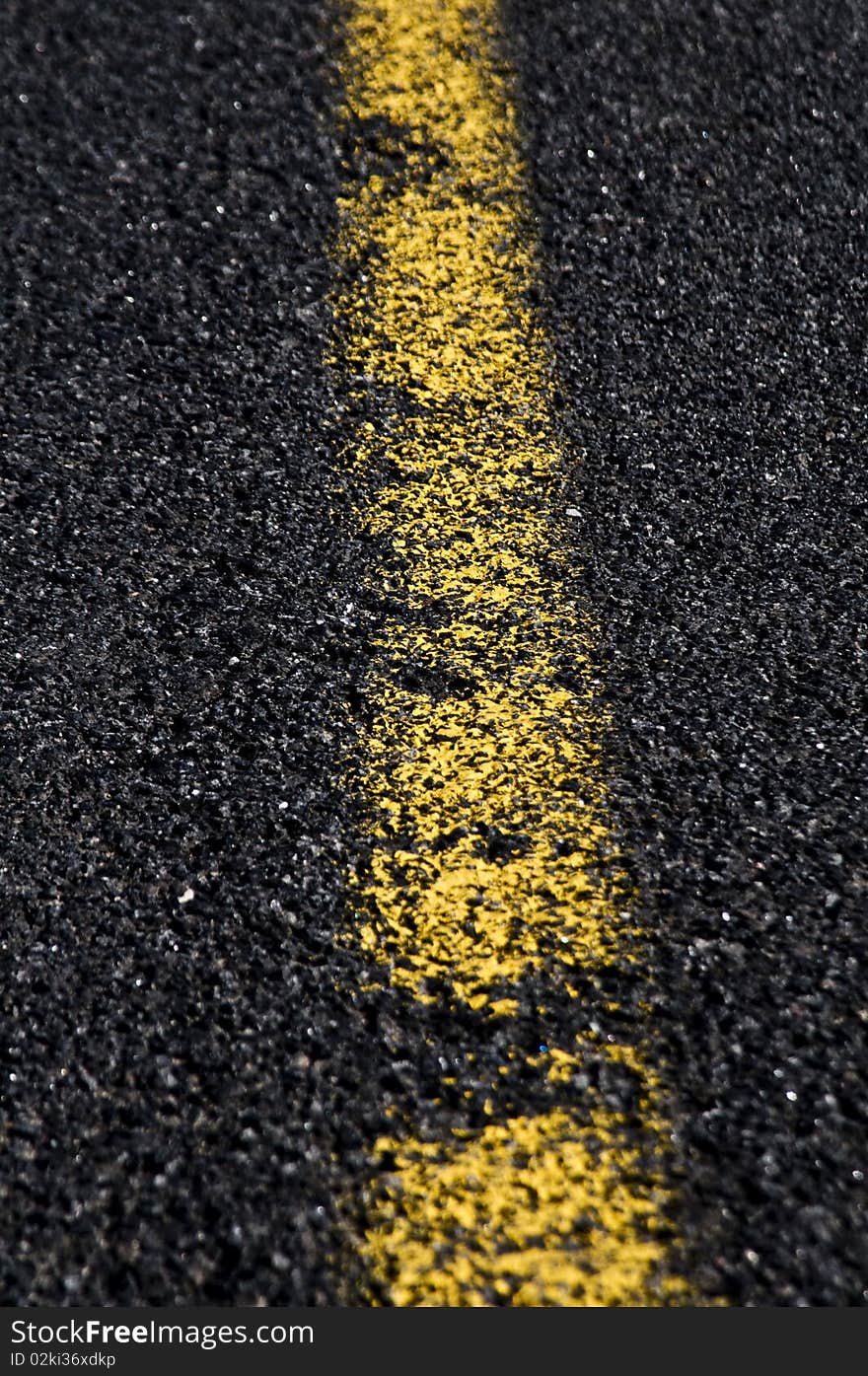 Traffic lines on asphalt showing a yellow center line. Traffic lines on asphalt showing a yellow center line