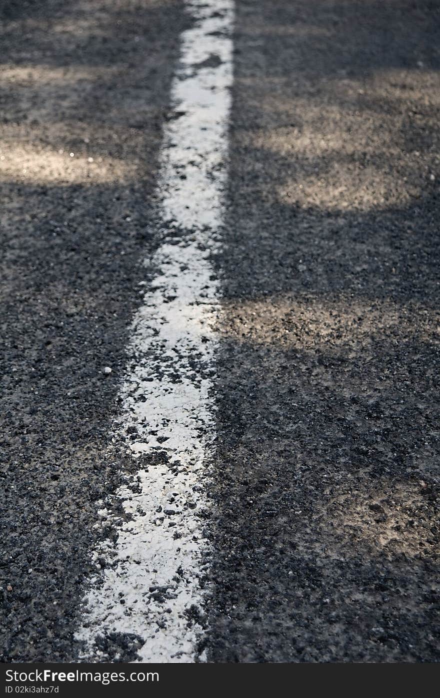 Traffic lines on asphalt showing a white center line