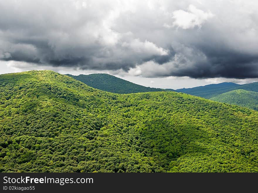 Green mountains under a dense clouds