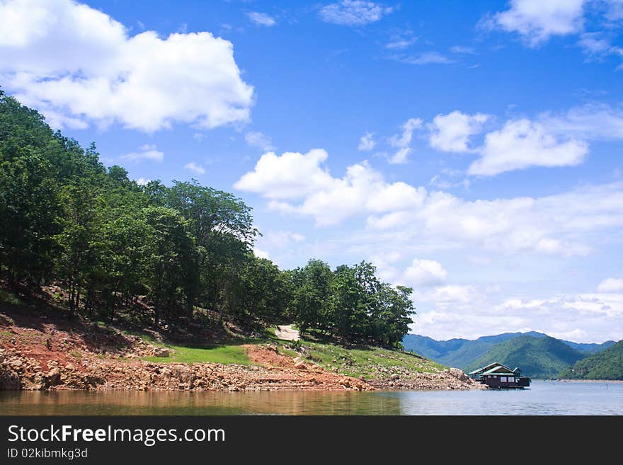 Houseboat and the mountain on the blue sky background. Houseboat and the mountain on the blue sky background