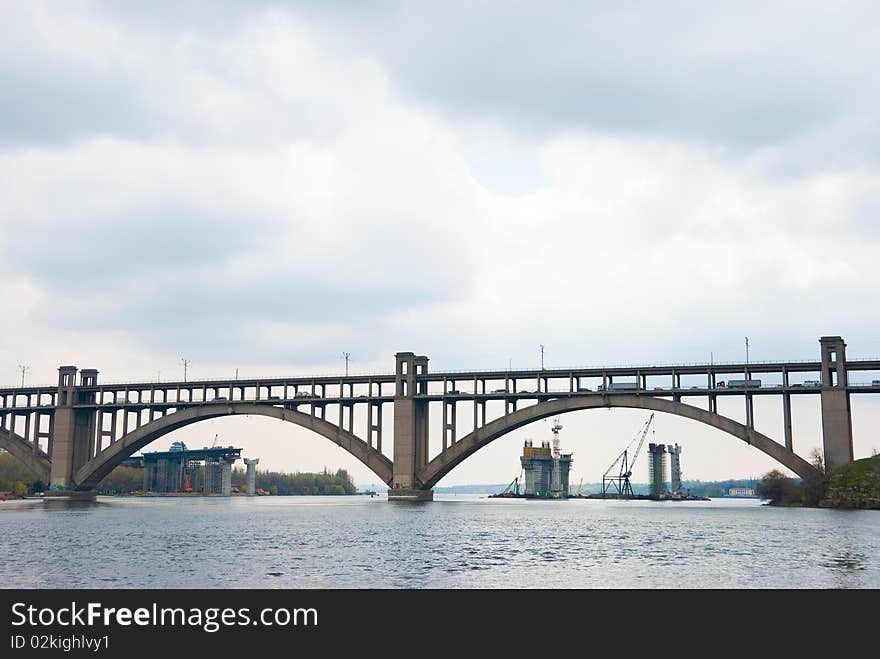 Multilevel bridge across the river. In the background construction of a new bridge. Multilevel bridge across the river. In the background construction of a new bridge