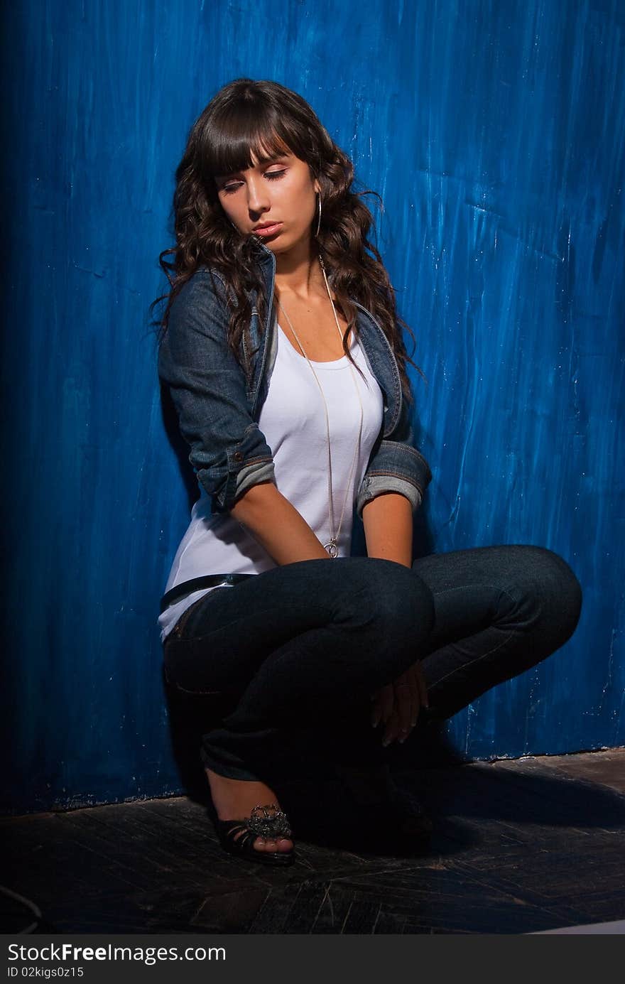 Beautiful young woman portrait in studio over grunge blue background